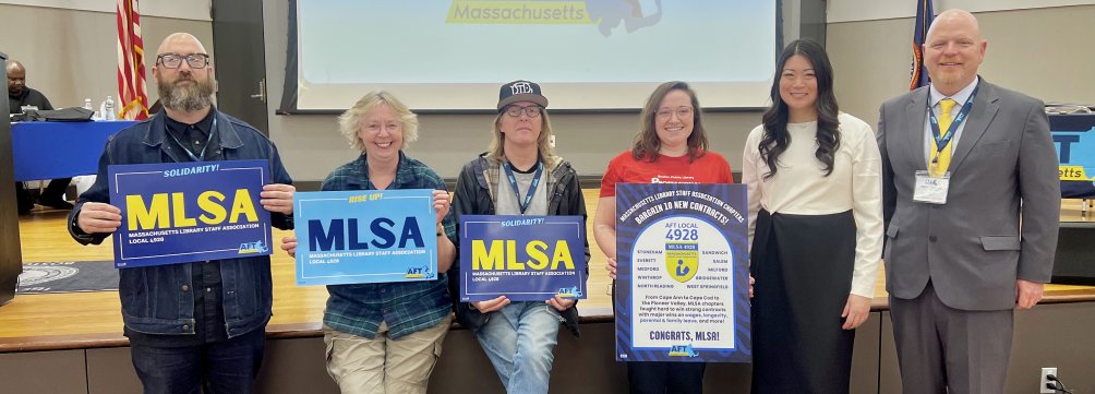 Six people stand in a line holding signs that say MLSA.